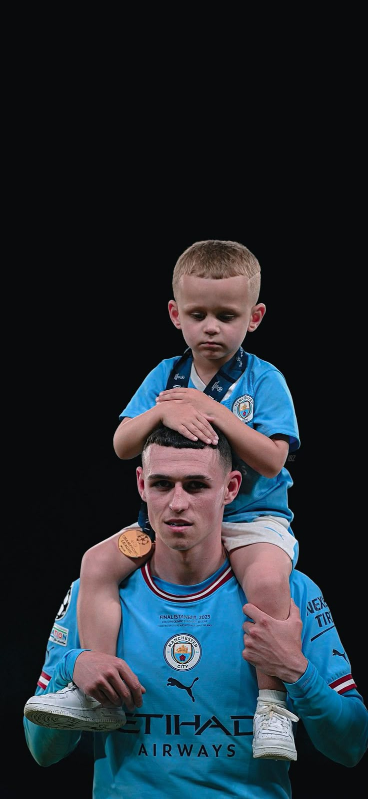 a man holding a young boy on his shoulders in front of a black background,