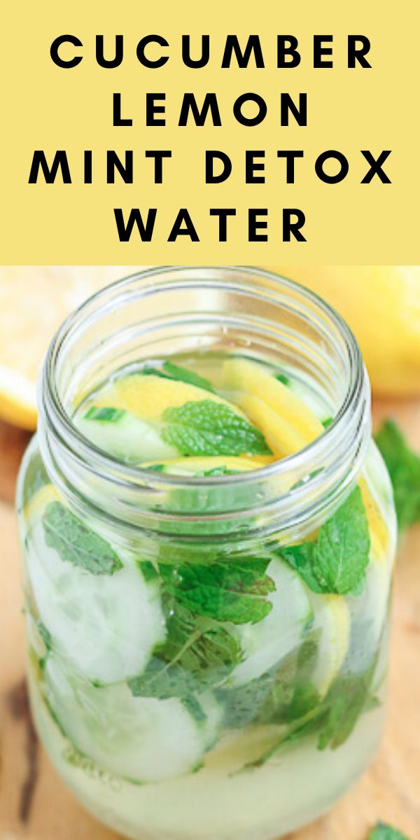 a mason jar filled with cucumber and lemon slices on top of a cutting board