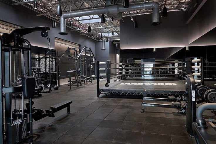 a gym with rows of exercise equipment in the middle and overhead lighting on the ceiling