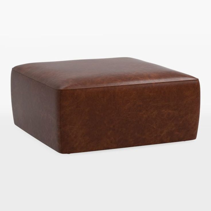 a brown leather ottoman sitting on top of a white floor