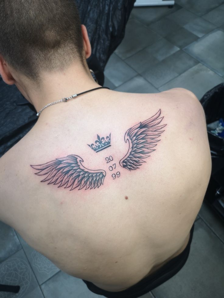 a man with a crown and wings tattoo on his back