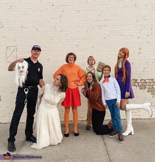 a group of people standing next to each other in front of a white brick wall