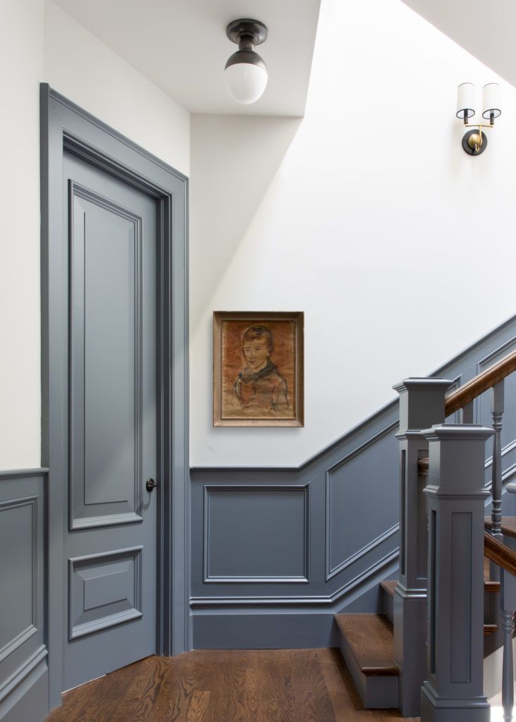 an entryway with blue painted walls and wooden stairs, along with a painting on the wall