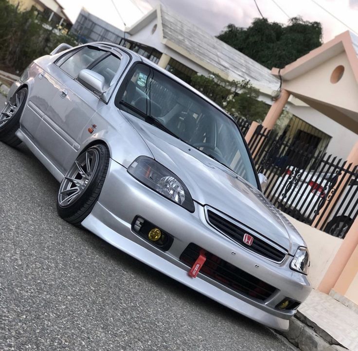 a silver car parked in front of a house