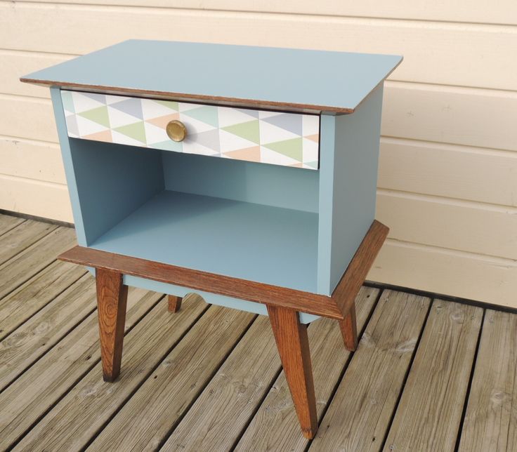 a small blue table sitting on top of a wooden floor next to a white wall