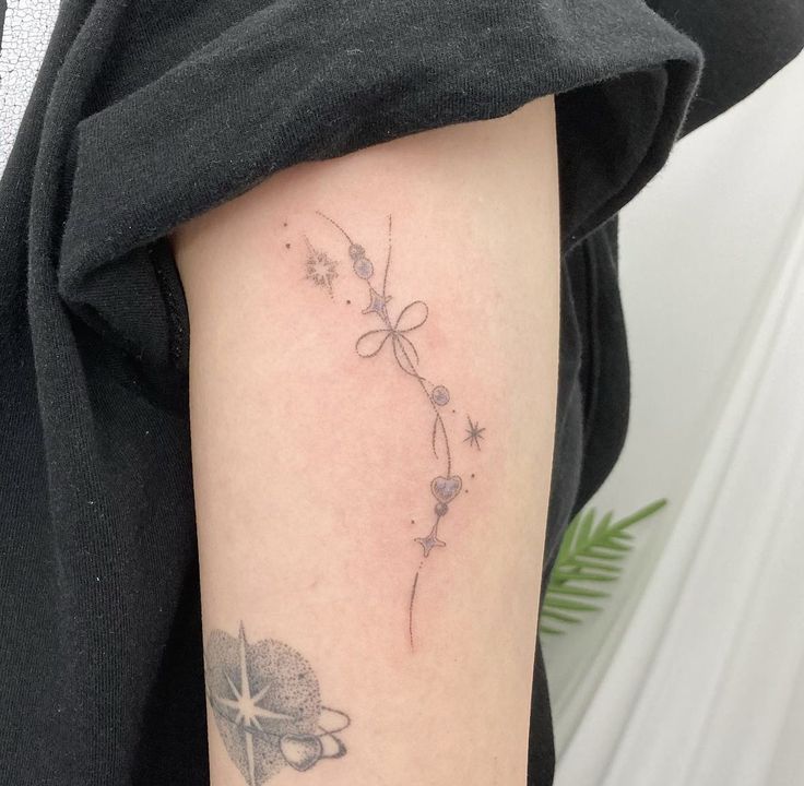 a woman's arm with a tattoo on it that has flowers and a star