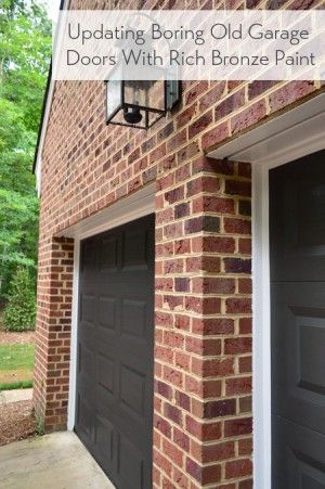 a brick building with two garage doors and a light on the side of the building