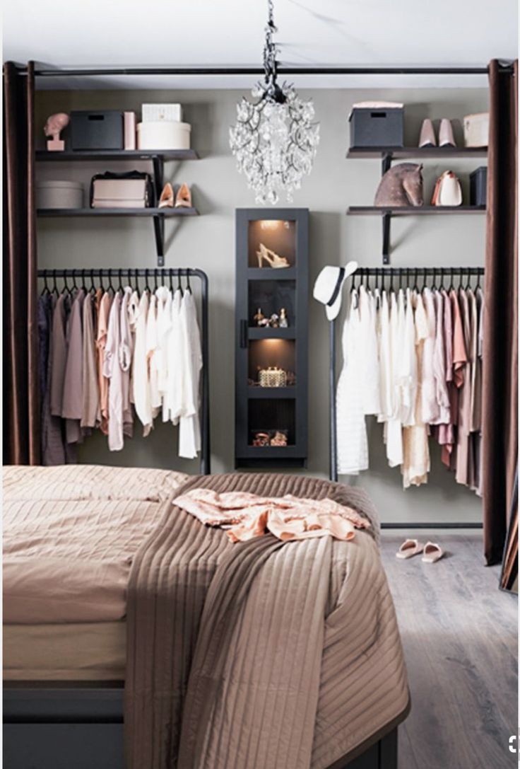 a bedroom with closets and clothes hanging on the wall next to it's bed