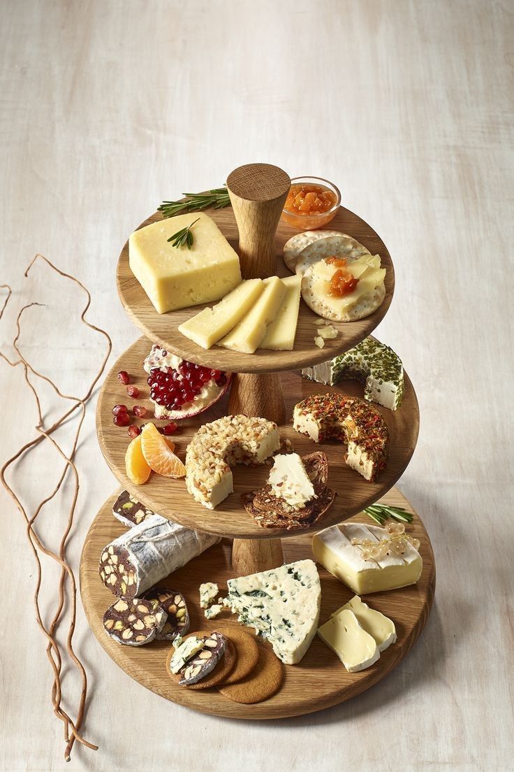 three tiered tray with cheese and crackers on it