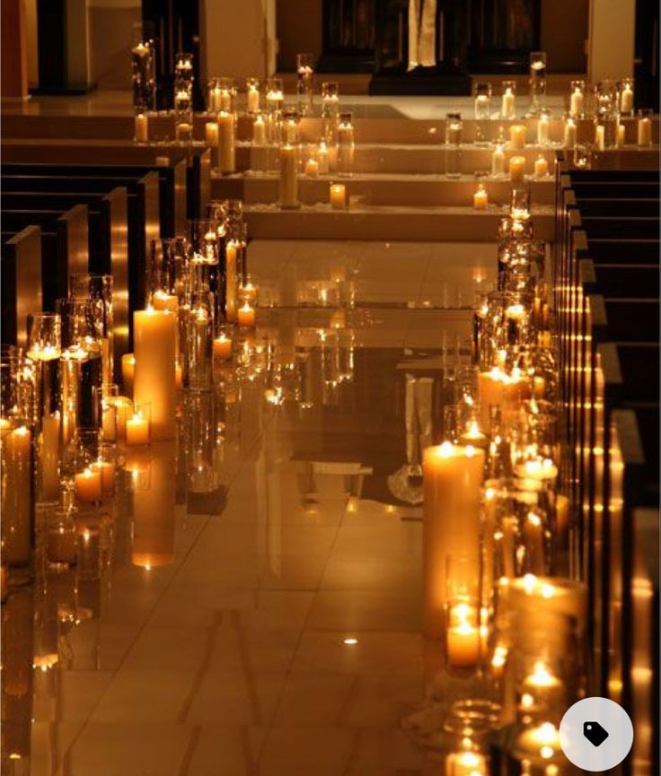 rows of candles are lined up in front of the alter