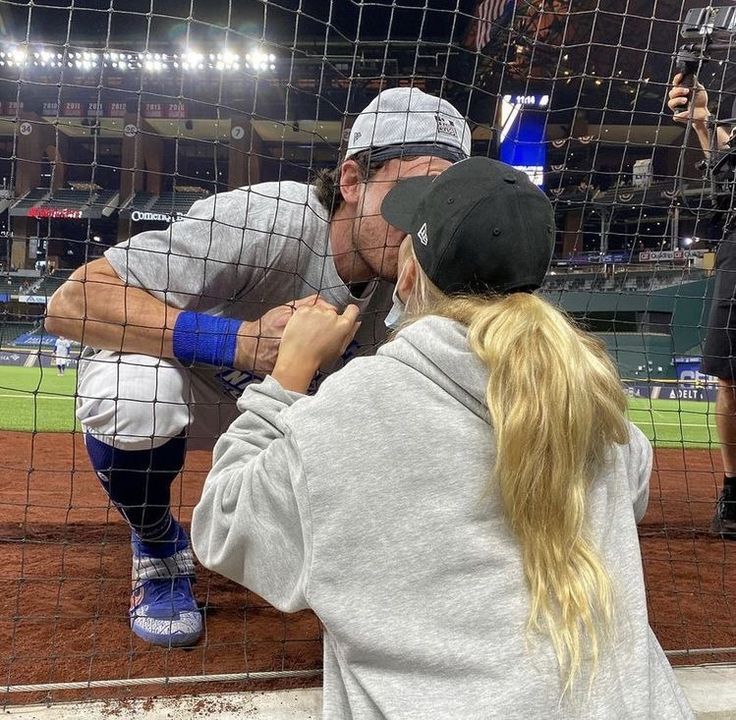 a man and woman standing next to each other on a baseball field