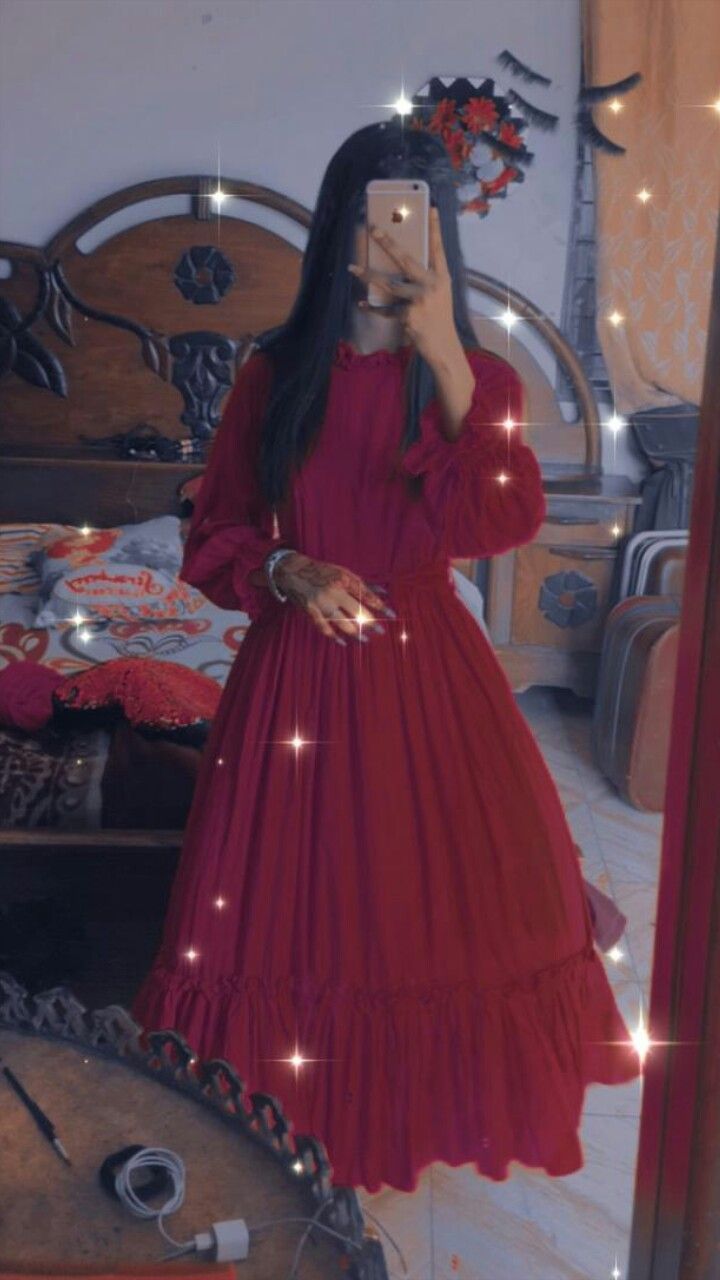 a woman in a red dress taking a selfie with her cell phone while standing in front of a mirror