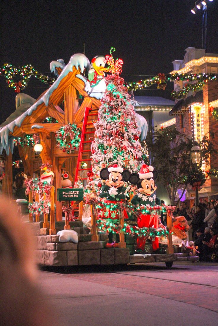 the mickey mouse christmas tree is lit up at night