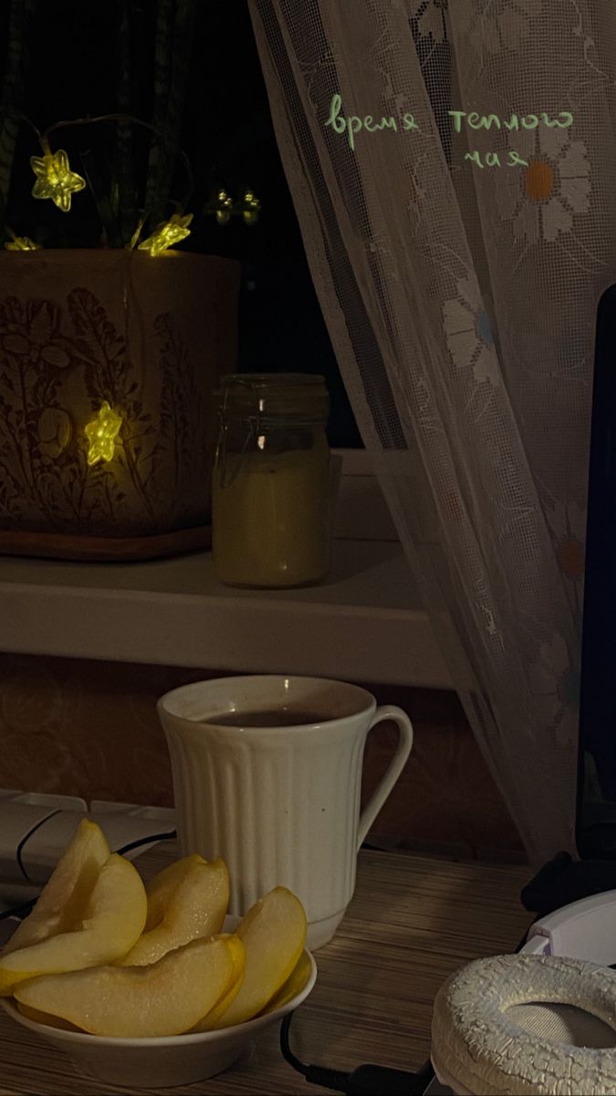 a laptop computer sitting on top of a desk next to a bowl of fruit and a cup