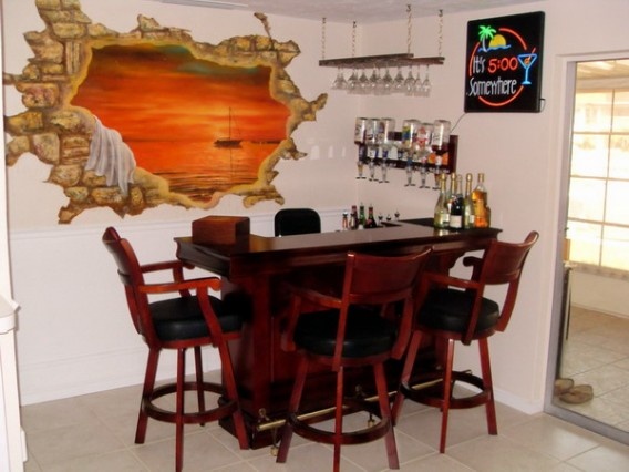 there is a bar with four stools at the end and a painting on the wall behind it