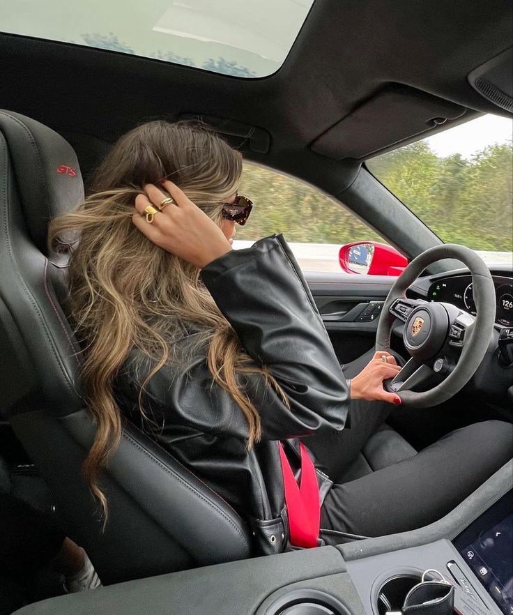 a woman sitting in the driver's seat of a car