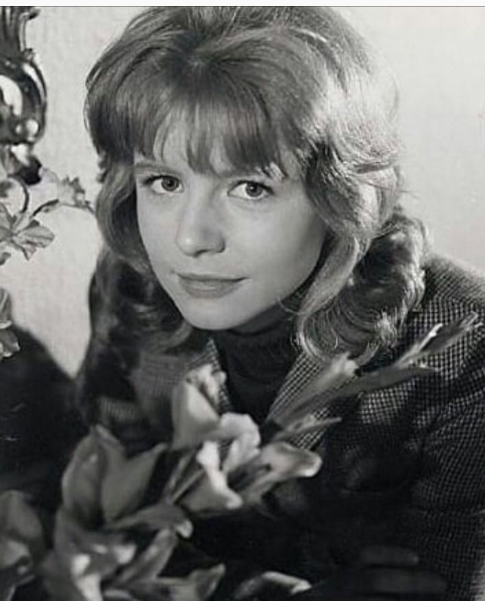 a black and white photo of a woman holding flowers