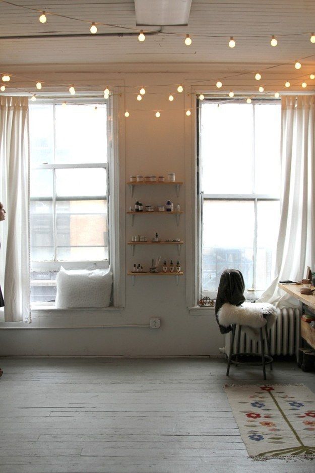 a living room with two windows and lights on the ceiling