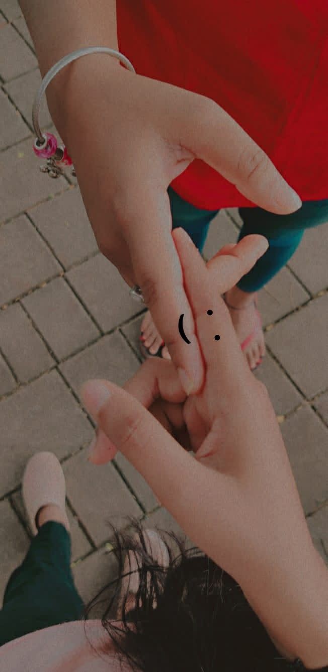 two people holding hands over each other on a brick walkway with one person's hand reaching for the other