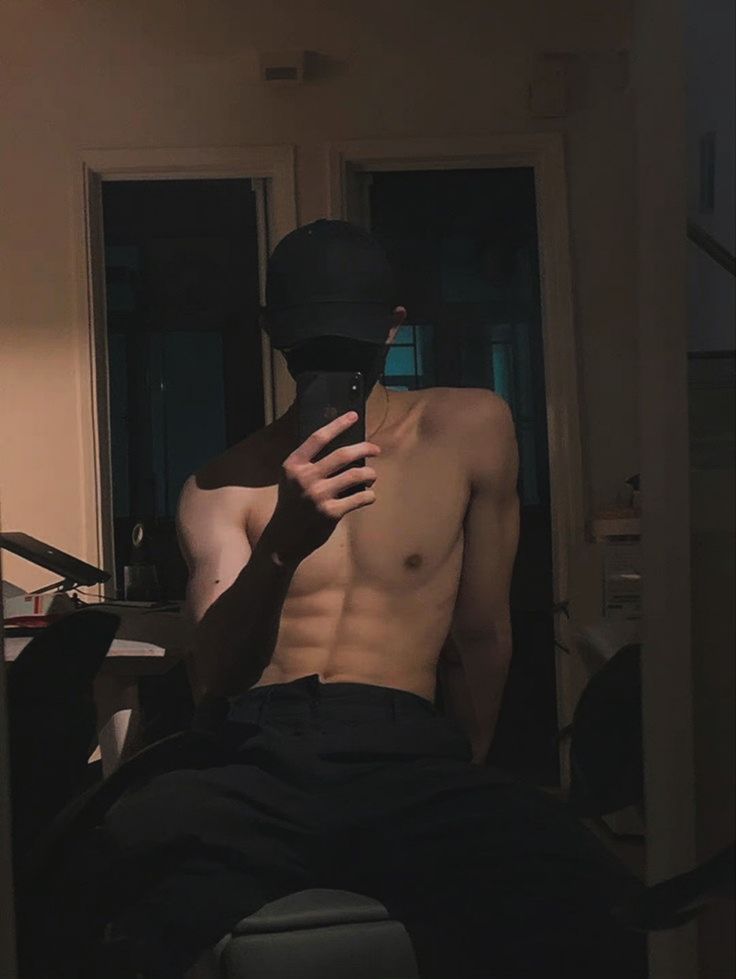 a shirtless man is taking a selfie in the mirror with his cell phone