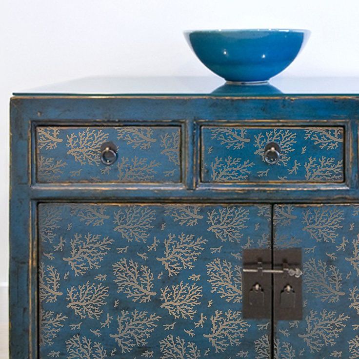 a blue painted cabinet with a bowl on top