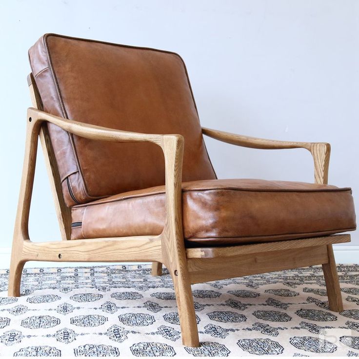 a brown leather chair sitting on top of a rug