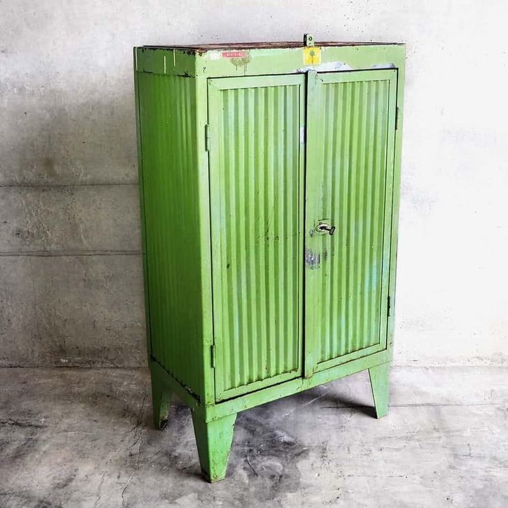 an old green metal cabinet with two doors