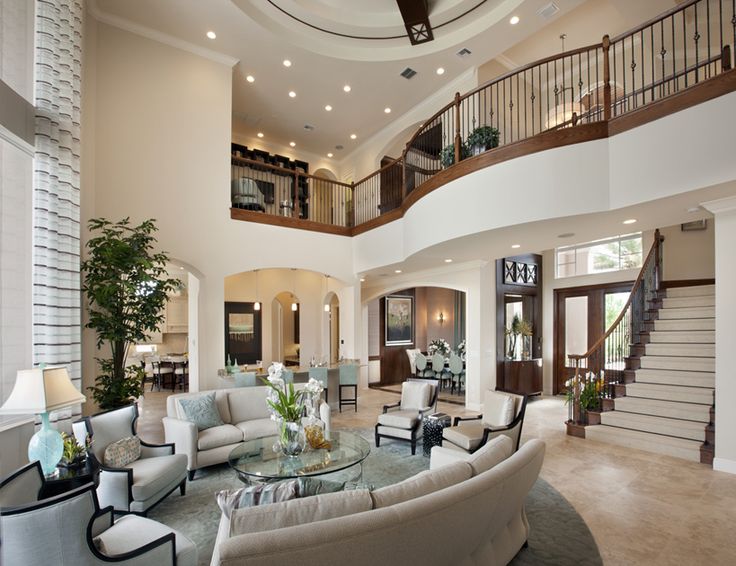 a living room filled with lots of furniture and a spiral staircase leading up to the second floor