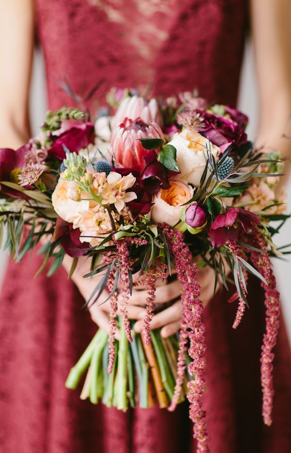 a woman in a red dress holding a bouquet of flowers