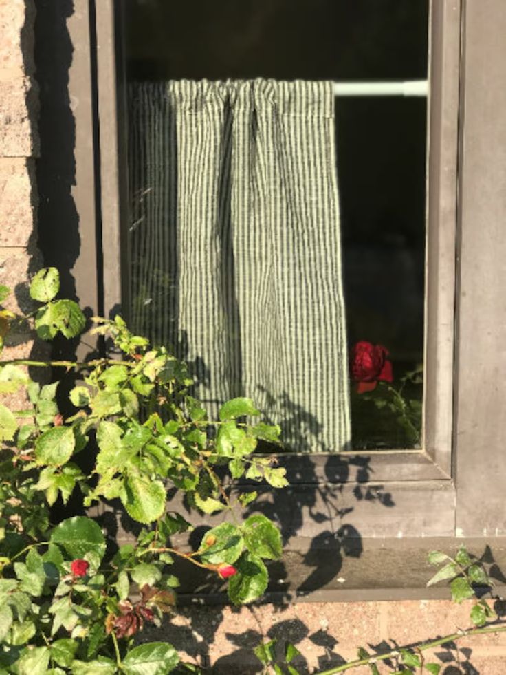 an open window with green and white striped curtains