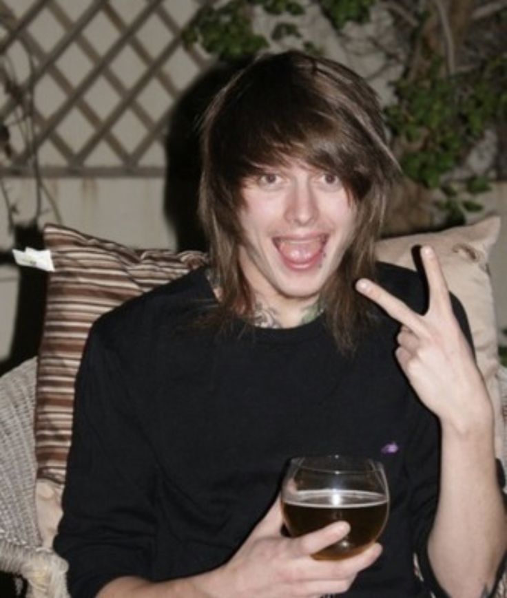 a man sitting on a couch with a glass of wine in front of his face