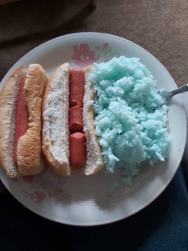 two hotdogs on a plate with blue mashed potatoes