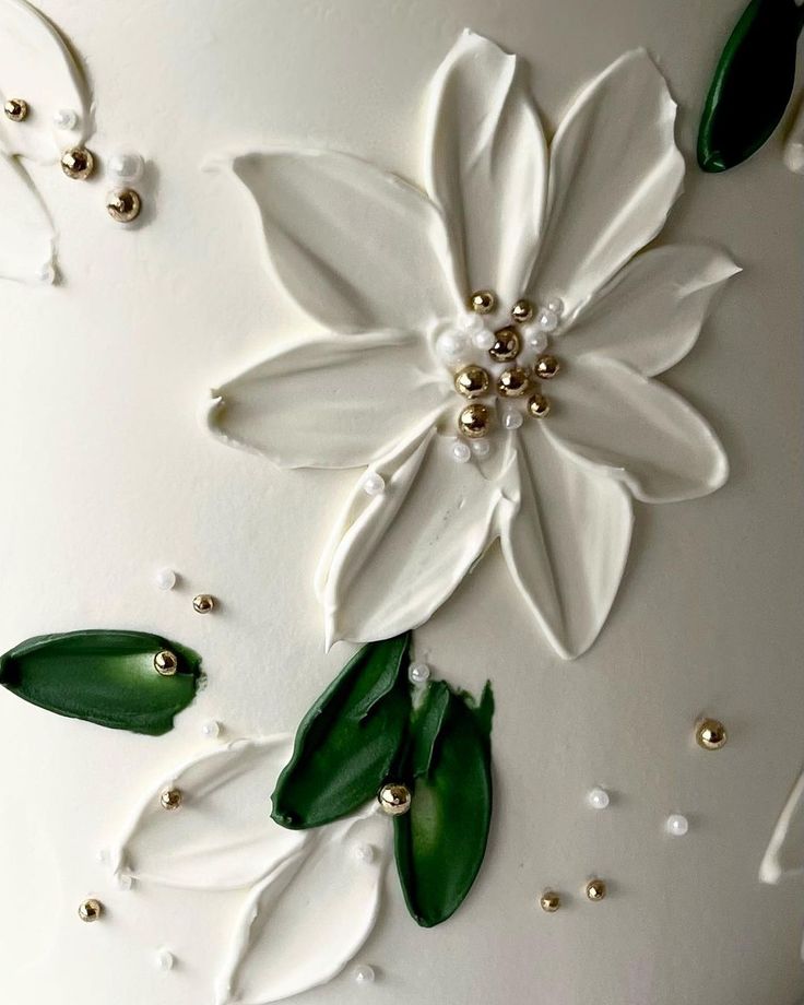 a white cake decorated with flowers and pearls