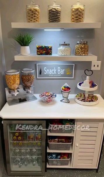 a snack bar with snacks and drinks on the counter in front of shelves filled with candy