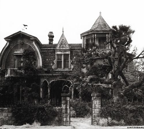 an old house with ivy growing on it's sides and two towers in the background