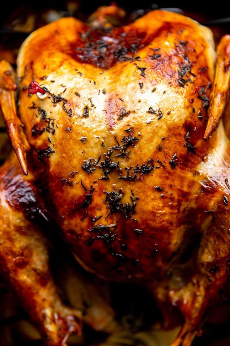 a roasted chicken with herbs on it