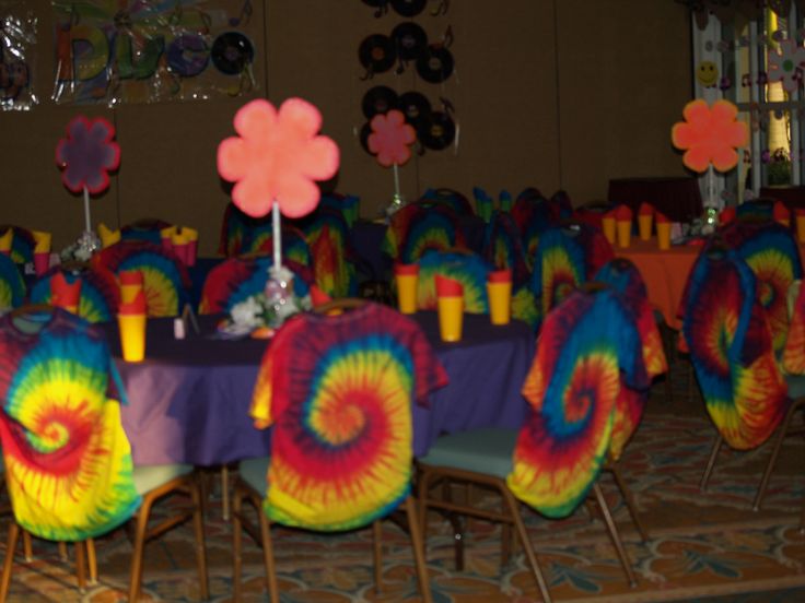 the tables are covered with colorful tie - dyed tablecloths and place settings for an event