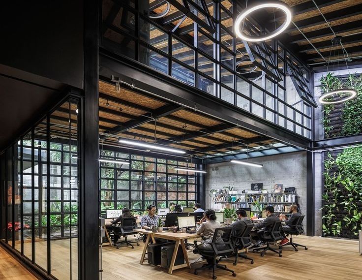 an office with lots of desks and people working on computers in the middle of it