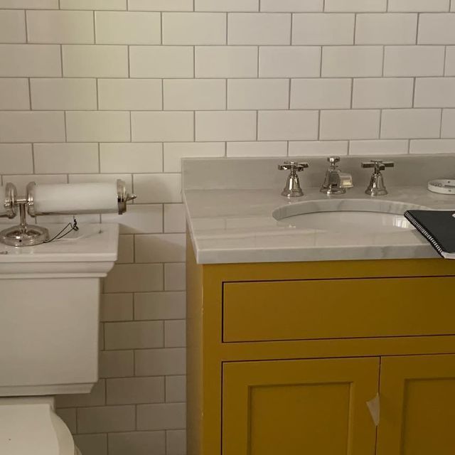 a white toilet sitting next to a bathroom sink under a faucet mounted on a wall