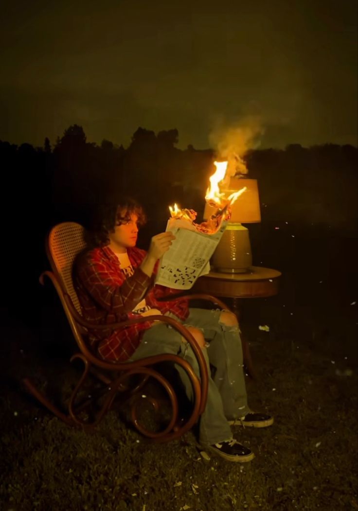 a man sitting in a chair next to a fire