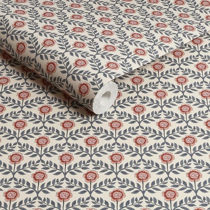 an image of a wallpaper with red and blue flowers on the background, as well as a roll of toilet paper