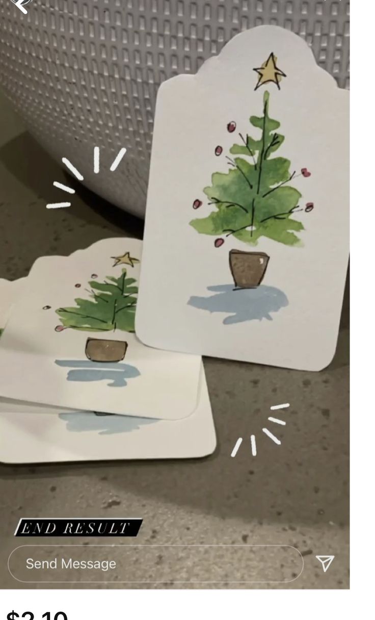 two tags with christmas trees on them sitting next to a potted plant and the tag says send message