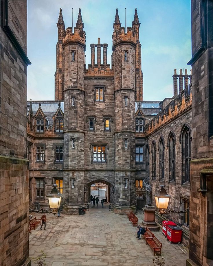 an old castle with many windows and some benches in front of the entrance to it