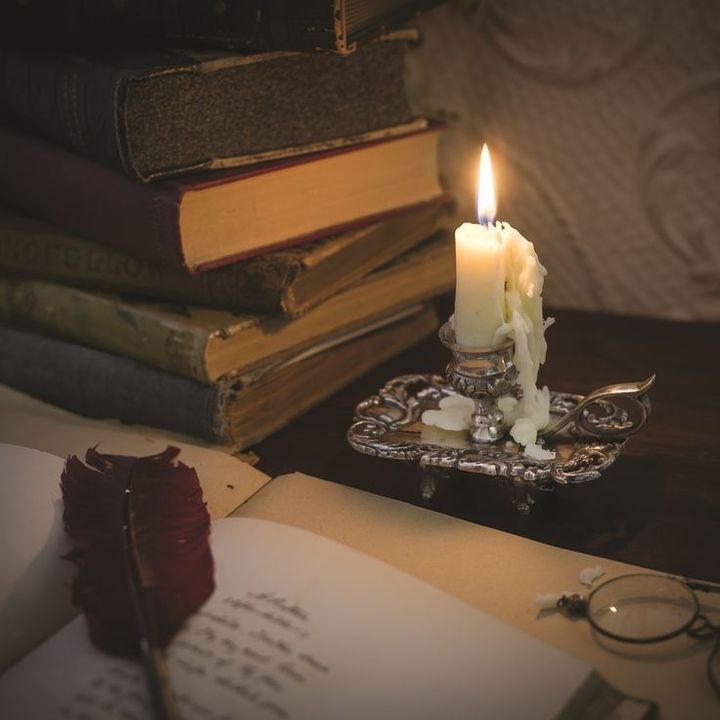 a lit candle sitting on top of an open book