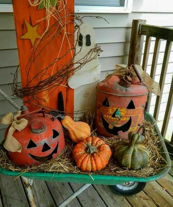 pumpkins and gourds are sitting on a wheelbarrow