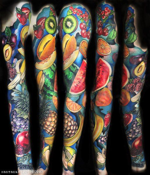 some very colorful tattoos on the arms and legs, with fruits and vegetables all over them