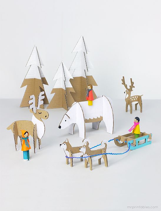 paper cut out animals and people on sleighs in front of snow - covered trees