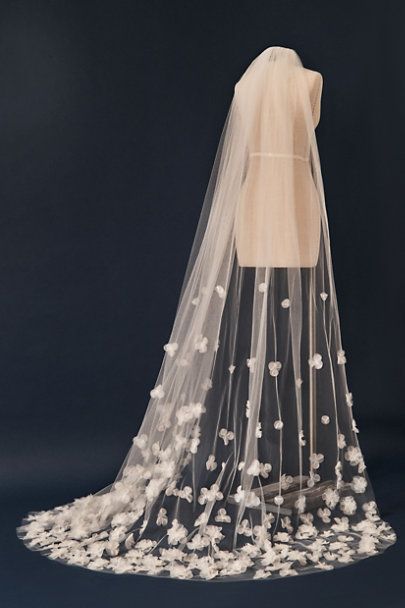 a wedding veil with white flowers on the bottom is shown against a black background,