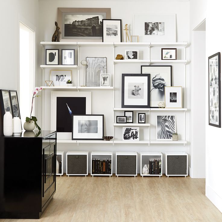 a room filled with lots of white shelves and pictures