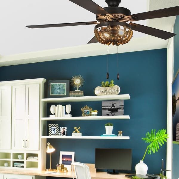 a ceiling fan is hanging from the ceiling in a room with blue walls and white furniture